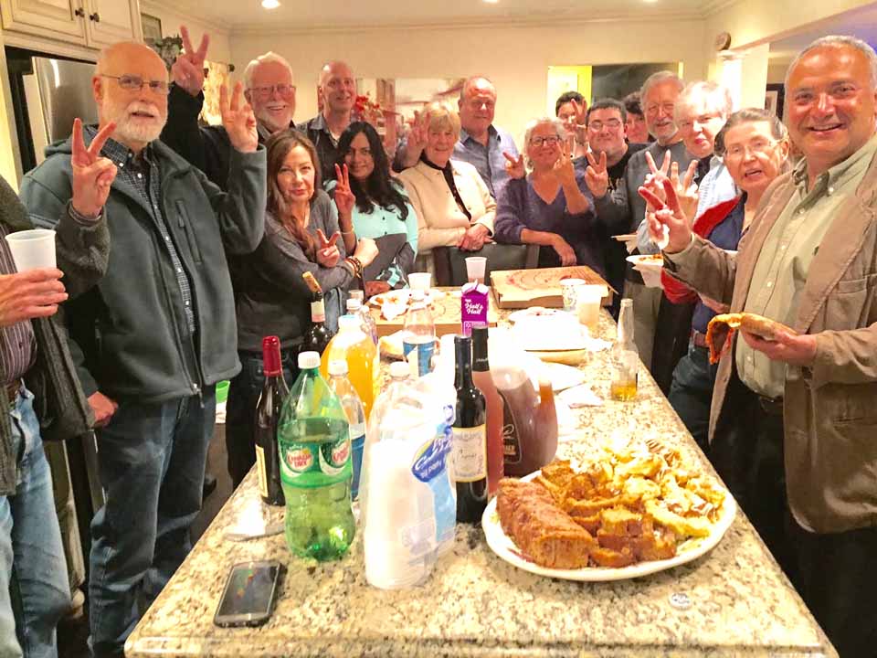 Attendees at Democratic County Chair Richard Abbate's Debate Party last evening at his Cooperstown home flash "V" signs to indicate who they thought won. (Jim Dean photo)
