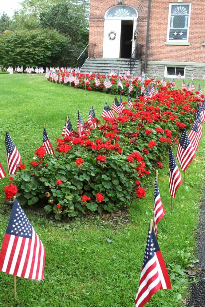 Hundreds of small American flags are decorating the lawn of the First United Methodist Church, as well as that of St. Mary's "Our Lady of the Lake" Roman Catholic Church, as worshipers attend services this morning on the 15th anniversary of 9/11, the attack on the Twin Towers. (Jim Kevlin/AllOTSEGO.com)