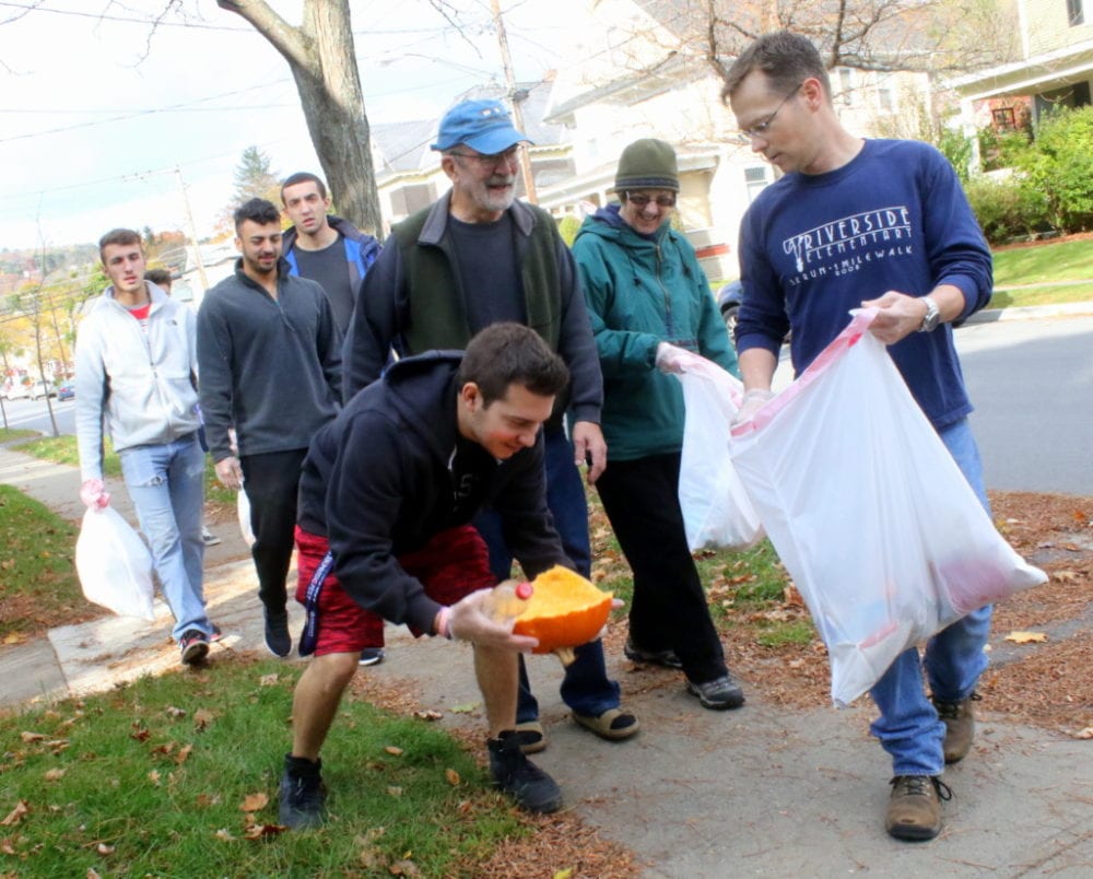 3rd ward councilman Dave Rissberger, right, holds a bag as SUNY volunteer Jacob Perez as he picks up trash along Elm St. Behind them are 3rd ward residents Charlie and Marty Winters, and volunteers from Hartwick's Alpha Omicron Pi and SUNY's Phi Kappa Jon Corado, Dylan Alves and Nick Marcella, who all took part in the 4th annual neighborhood clean up this morning.(Ian Austin/AllOTSEGO.com)