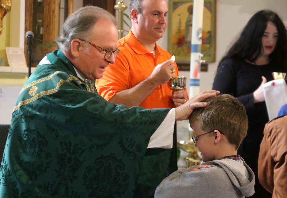 Father Patrick J. Conroy, chaplain of the U.S. House of Representatives, gives Holy Communion a few minutes ago at St. Mary's "Our Lady of the Lake" Catholic Church a few minutes ago at he conclusion of 11 a.m. mass. He preached on Sirach 35:15-22, "The prayer of the humble pierces the clouds, and it will not rest until it reaches its goal." He asked parishioners to contemplate the text prior to the upcoming election. Father Conroy is filling in for the vacationing Father John P. Rosson, the pastor. (Jim Kevlin/AllOTSEGO.com)