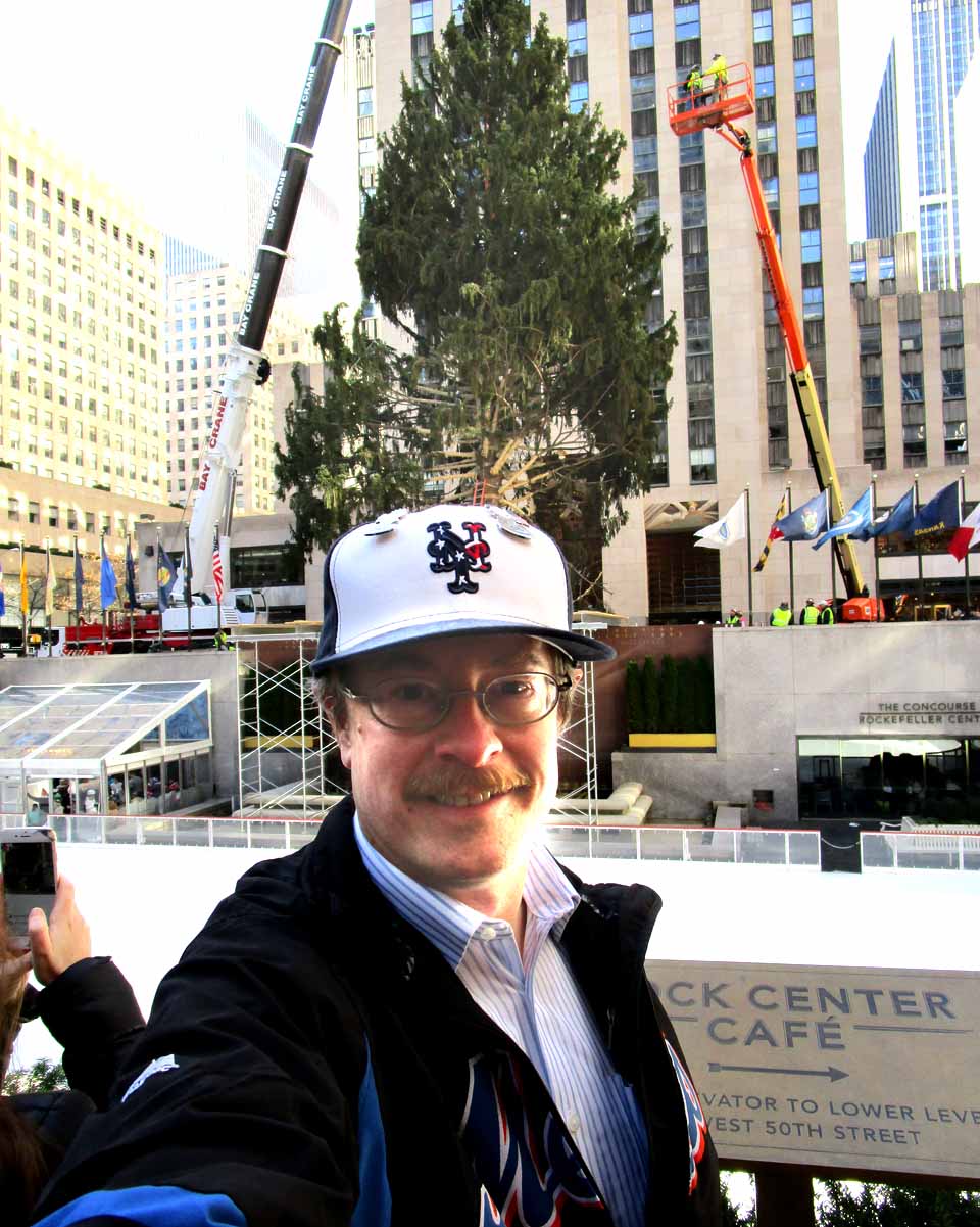 Glenn Linsenbardt of Hartwick, who works for the county Office for the Aging, snaps a photo at Rockefeller Center Saturday, where he witnessed the placement of this year's Christmas tree – it grew on the Eichler family's lot on Country Club Road, Oneonta – next to the rink. The huge will decorated and lit on Nov. 30. Lisen