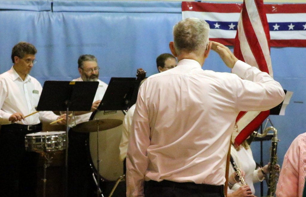 Bradley Osborne, Oneonta, who served in the U.S. Army and Airforce, salutes the flag as Oneonta Community Concert Band plays "Star Spangled Banner" at St, Mary's this evening. The song was one of many military-themed selections the band has chosen for their 17th Annual Salute To Veterans Concert held this afternoon. Each branch of the military was recognized and honored. Cake, coffee and conversation closed out the event. (Ian Austin/AllOTSEGO.com)