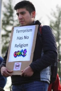 During a moment of silence for those killed by hate crimes, Stefan Segelken holds his sign "Terrorism Has No Religion."