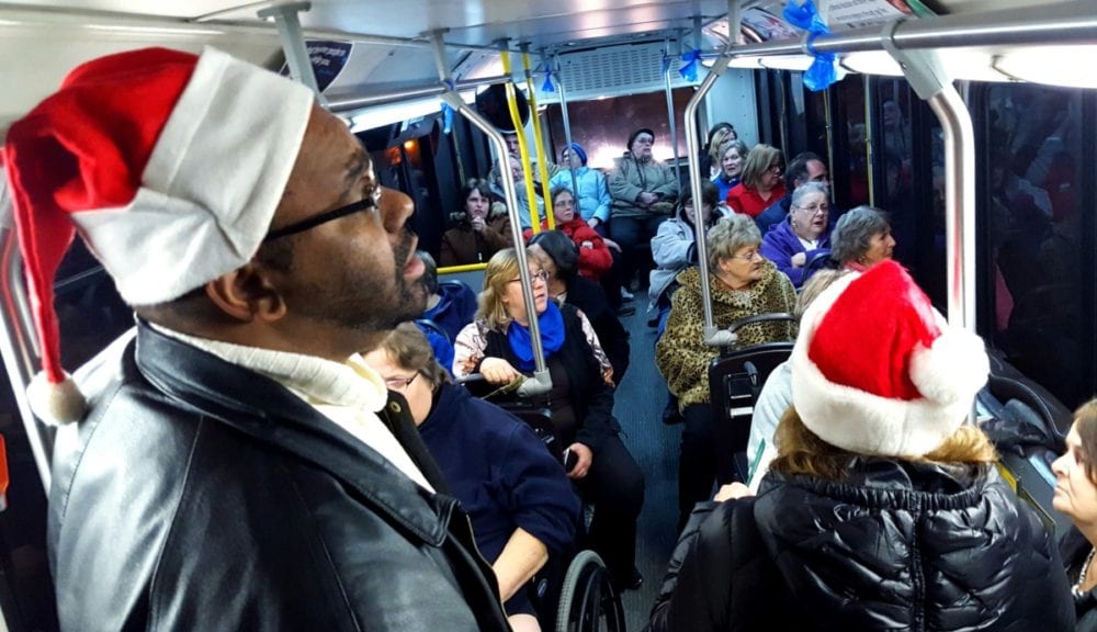 If you saw a packed OPT bus making it's way around residential streets this evening, rest assured they weren't lost! The bus, driven by Paul Patterson, was taking residents of Nader Towers on a city-wide tour of Christmas lights. D.J. Wooden and Julie Pitell, seen in the foreground, lent their vocal talents by singing Christmas songs with the riders to get everyone in the spirit. The event, organized by Carla Balnis, was so popular that she intends to expand it for next year to include rides for Academy Arms and Peaceful Flatts. (Ian Austin/AllOTSEGO.com)
