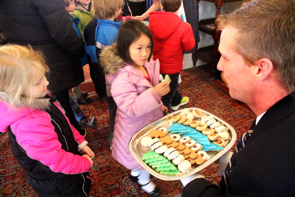 The Otesaga's Robbie Huntington hands out cookies to CCS pupils who, as is traditional, sang Chrismas carols to the Cooperstown Rotary Club at its luncheon meeting today.  (Jim Kevlin/AllOTSEGO.com)