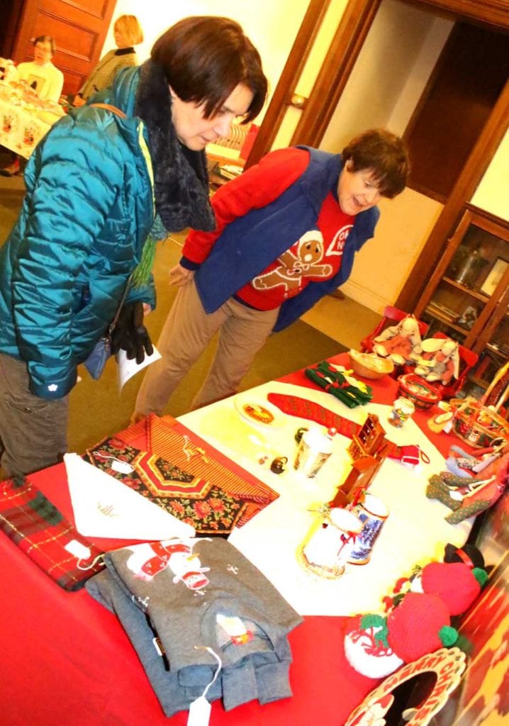 Colleen Sullivan and Sue Straub of Fly Creek perused offerings at today's Christman Bazaar & Tea underway until 4 p.m. at Cooperstown United Methodist Church. Check the Happenin' Otsego calendar (below) for all the holiday activities. (Jim Kevlin/AllOTSEGO.com)